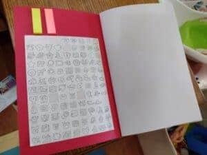 A picture of a notebook for a toddler with sticky tabs and stickers