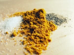 salt, pepper and curry on a wood board