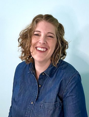 Christina Hidek smiling against blue wall
