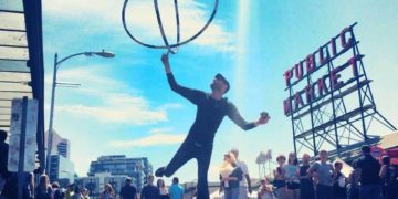 A busker juggles outside of pike place market in seattle