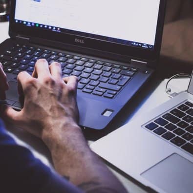 man typing on laptop