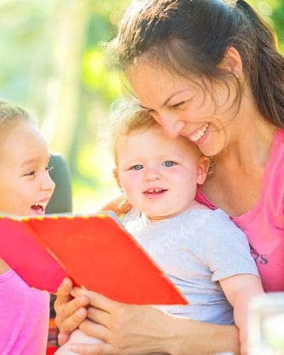 Tips-for-Homeschooling-while-paying-off-debt.-Mom-reads-library-books-to-her-kids