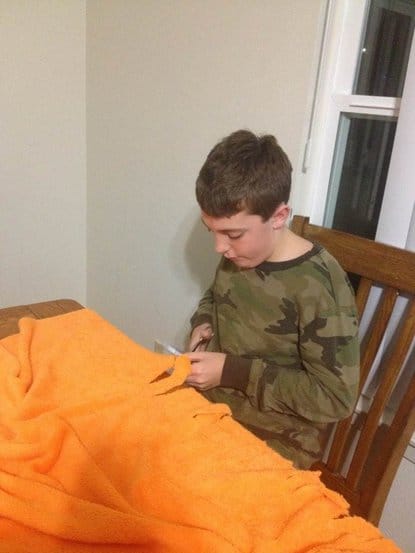 Jonathan (age 11) cuts his minkee fringe blanket