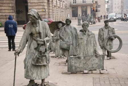 Ein weltweit bestauntes und verschieden interpretiertes Denkmal an der Kreuzung Swindnicka / Marszalka. Bronzene Menschen verschwinden in der Erde (gegenüberliegend), andere tauchen hier auf. „Kampf und Sieg der Polen aus dem Untergrund gegen den Kommunismus“ wird Jerzy Kalinas Werk „Anonyme Passanten“ offiziell gedeutet; den grausamen Austausch der deutschen Bevölkerung gegen Vertriebene aus Ostpolen sehen Touristen.