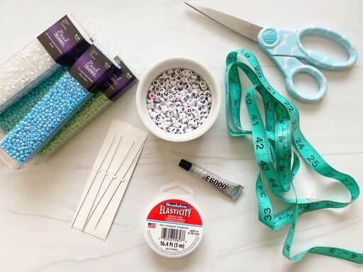 supplies for making braclets on a white table.