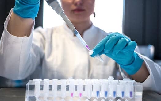 Female Lab Technician Filling Vials with Fluid