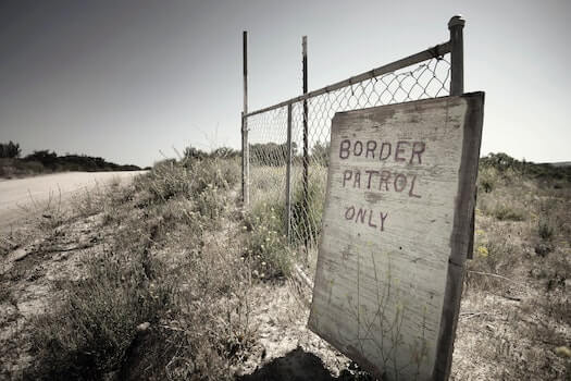 Border Patrol Only Sign Propped Against Partial Section of Fence