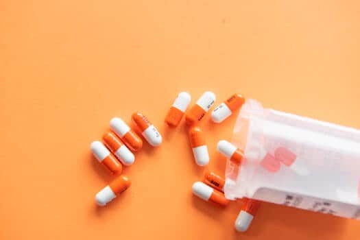 Prescription Pills Spilled from a Bottle Across a Table