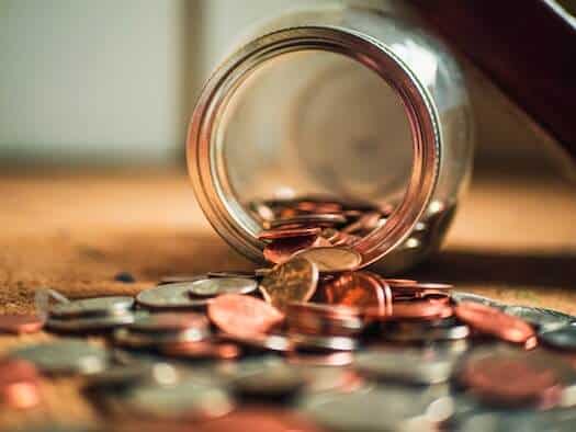 Overturned Jar with Coins Spilling Out Onto the Floor