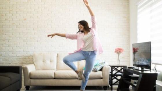 woman in living room doing dancing meditation