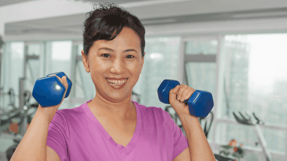 Woman lifting weights for better bone health. Exercise fights osteoporosis.