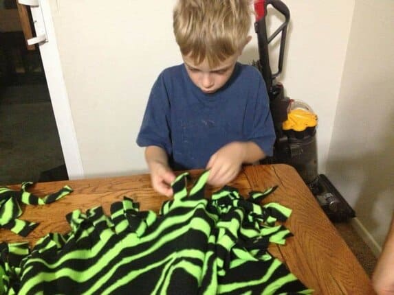 Looking for an easy craft for your kids to make?  A no-sew fringe blanket is perfect for kids at a pretty early age.  They will need a little help but essentially can do it themselves. 