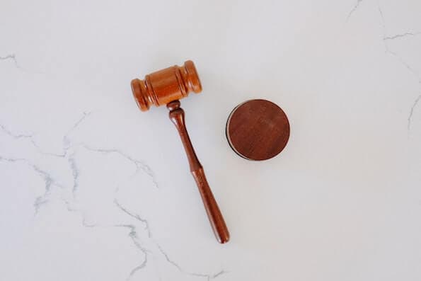 Gavel and Round Sound Block Sit on Marble Surface