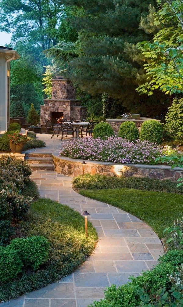 a stunning retaining wall cap idea filled with purple geraniums for a sophisticated garden