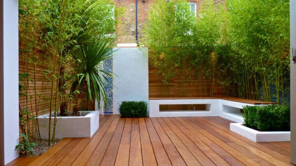 plant trees on a small backyard deck with slatted cedar fencing to evoke a cozy and refreshing contemporary mood