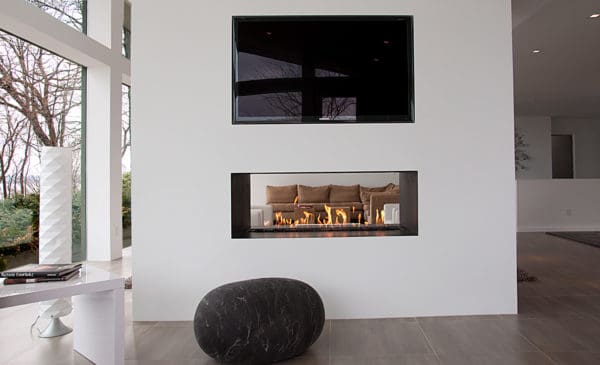 consider a black and white living room with a two-sided linear fireplace, mounted tv, and clean design