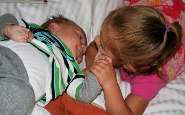 Traveling with a Newborn Playing on the Bed