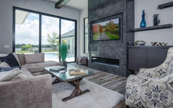 polished porcelain tile for linear fireplace and wall-mounted tv on gray walls make for a soothing living space