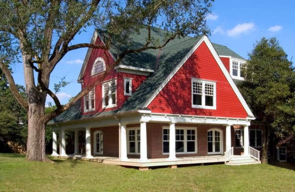 a funky red brick house looks stunning with red siding and green gable roof color