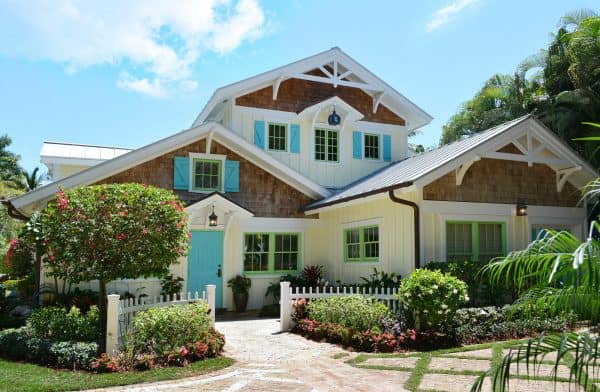 this yellow house has a fun contemporary vibe with blue shutters and green windowsills