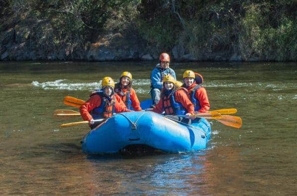 A family rafting on a calm river together