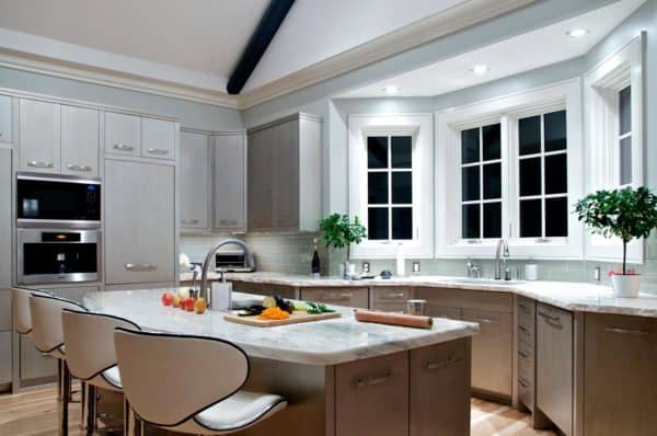 use glass tiled backsplash and gardenia topiaries to complement bay window over the sink