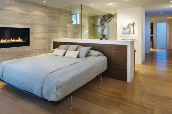 elegant headboard half wall with storage for open concept bedroom and shower area