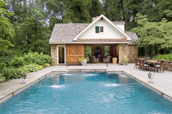 country pool house and bathroom with classic barn doors to complete an oversized swimming pool