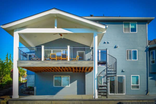 a stylish second-story deck with spiral staircase and cozy setup for bbq and outdoor dinners