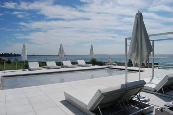 furnish stamped concrete tiles for a picturesque pool deck with multiple sun loungers for a resort-like vibe