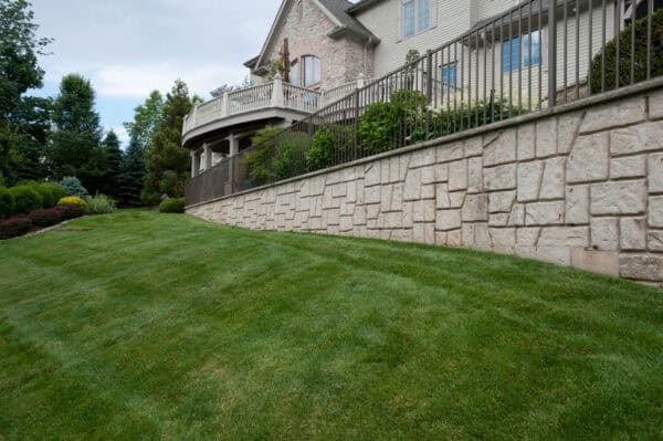 this aluminum fence on a high stone retaining wall evokes a lofty and lavish presence