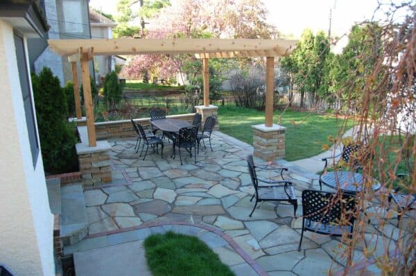 try an irregular bluestone patio with clay brick insets and a wall stone retaining wall for a natural vibe