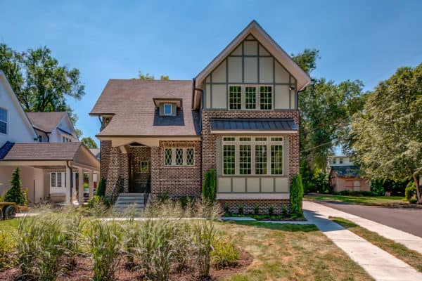 classic two-story red brick house matches its attractive red shingle roof creates countryside charm