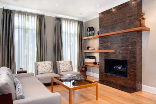 artistic ceramic tiles in front of red brick fireplace surround in a cozy living room in benjamin moore's bennington gray paint