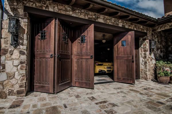 folding barn style garage door features dark walnut color in a rural italian-style home