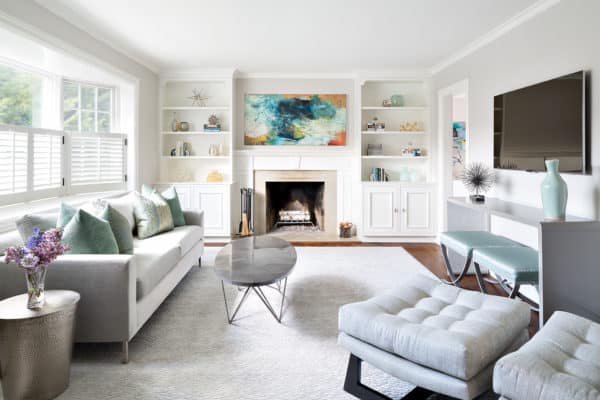 clean and cozy white living room with built-in shelves and warm grey furniture