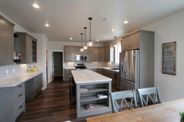 create a cozy eat-in kitchen featuring modern grey-stained cabinets and a modest island with built-in shelves