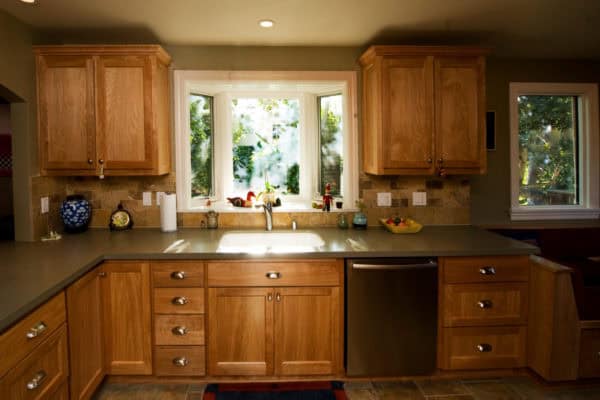 farmhouse kitchen looking cozy and warm with a bay window over sink and natural wood cabinets