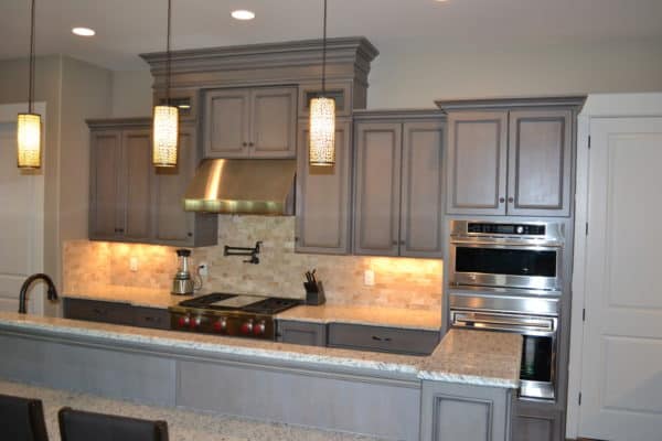 opt for a simple kitchen with grey-stained cabinets and warm pendant lights