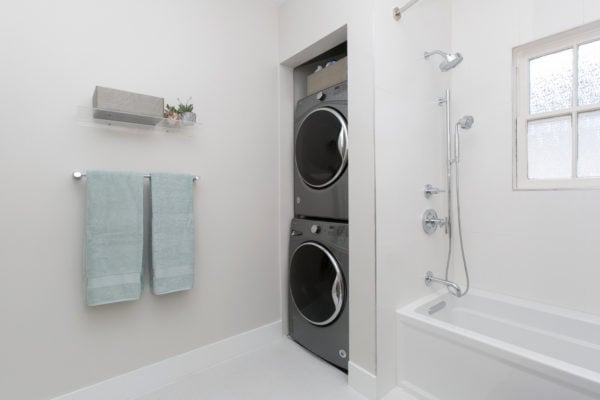 furnish bathroom laundry room combo with stainless-steel accents and clear glass shelf