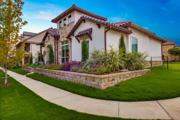 go for a mediterranean-inspired front yard retaining wall with concrete paver