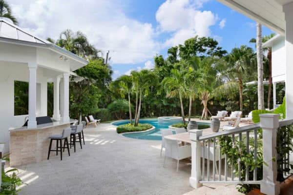 pair stamped concrete pool deck with palm trees and outdoor bar for a beachside resort style backyard