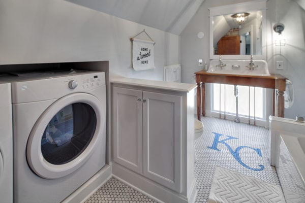 this bathroom laundry combo with cottage charm features custom ceramic tile flooring