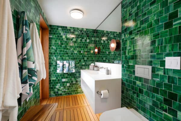 use mosaic tiles for fun green walls that complement the simple brown flooring