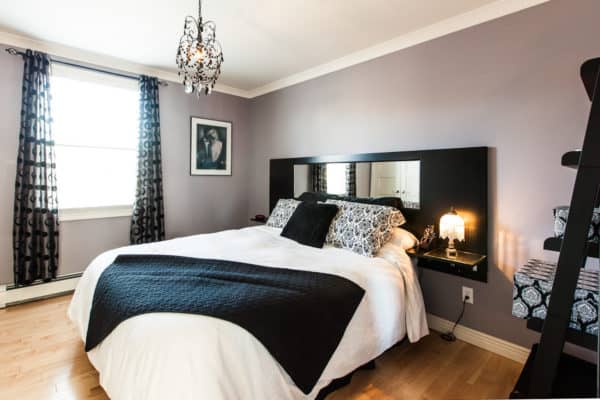 building mirrors into the black headboard to create the illusion of space in an apartment style bedroom