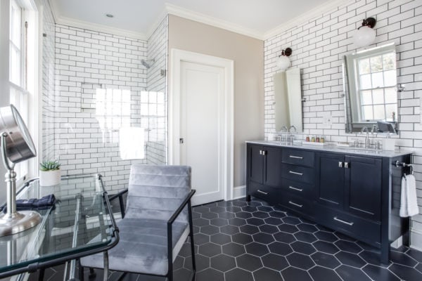 add a glass table vanity in addition to the subway tile with black grout shower walls and honeycomb tile bathroom floors