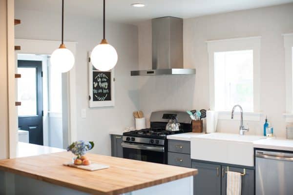 decorate a small kitchen with a wood countertop peninsula and ceramic backsplash for a quintessential modern interior