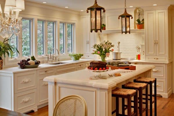 classic french country-inspired kitchen featuring benjamin moore linen white cabinets with white, honed calcutta marble countertops