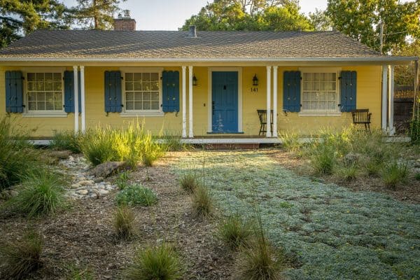 place chairs for the patio of a yellow house with blue shutters and white windowsills