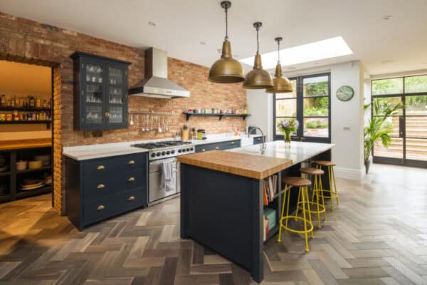 this open-concept galley kitchen with an island mixes exposed brick and wood for a charming farmhouse style